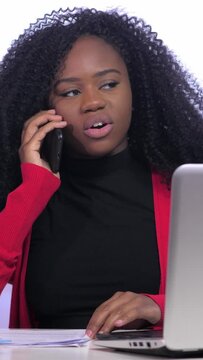 Young blacke woman working from home using mobile phone and laptop