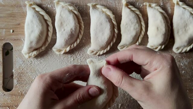 Close-up hands cooking dumplings dough