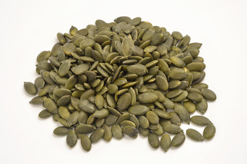 Photograph of a pile or stack of hulled pumpkin seeds without shell isolated on white background