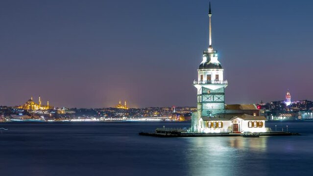 Maidens tower after sunset day to night transition timelapse in istanbul, turkey, kiz kulesi tower. City skyline on background with reflection on Bosforus water