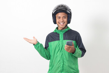 Portrait of Asian online taxi driver wearing green jacket and helmet holding mobile phone while...