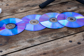 Obsolete set of CDs on a wooden table. Digital transition over a decade.
