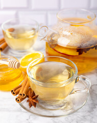 Fragrant hot tea with cinnamon stick and anise on a textured wooden background. A cup of hot tea with honey, lemon, mint and apples. Spicy tea with spices. Immunity tea. Health concept.Copy space.