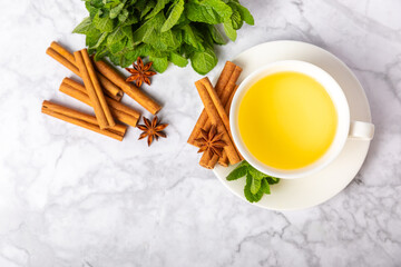 Fragrant hot tea with cinnamon stick and anise on a textured wooden background. A cup of hot tea...