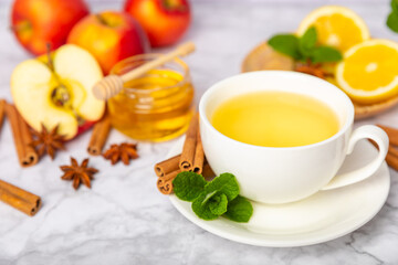 Fragrant hot tea with cinnamon stick and anise on a textured wooden background. A cup of hot tea...