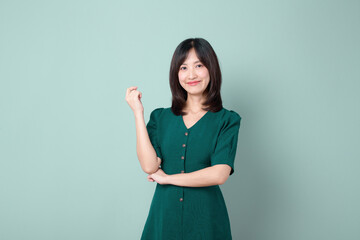 An Asian woman wearing green dresses isolated on green background