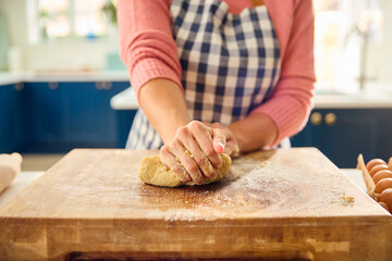 Close Up Of Woman At Home In Kitchen Making Dough On Worktop Or Counter