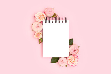 Blank notepad mockup. Rose flowers on a pink background.