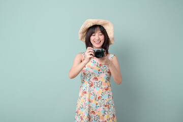 Happy Asian woman wearing casual dress and hat with camera on vacation or travel theme isolated on...