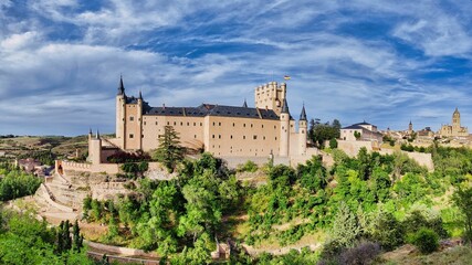 Majestic Segovia Castle surrounded by lush green trees. Spain