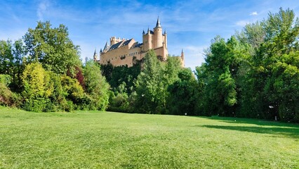 Majestic Segovia Castle surrounded by lush green trees. Spain