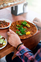 Traditional delicious Turkish foods; Lahmacun (Turkish pizza). Lahmacun traditional Turkish pizza and wraps with salad isolated on rustic wooden table.