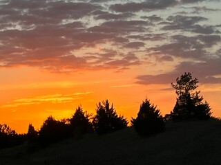 there is a kite flying in the sky with clouds at sunset