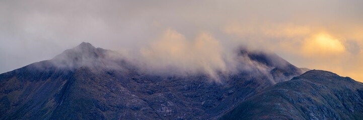 Fototapeta premium an airplane is flying near some mountains in the clouds in this time lapshot