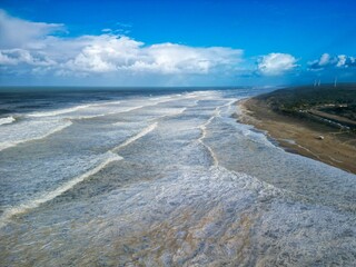 a view of an ocean from a flying airplane on the beach