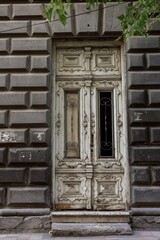 Ancient wooden door standing in contrast to the modern Armenian architecture of the surroundings