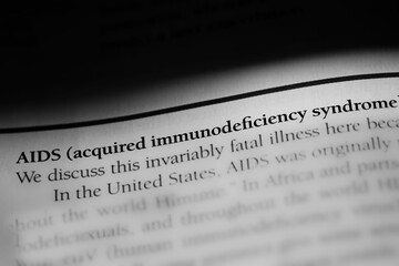 Close-up of the term AIDS, acquired immunodeficiency syndrome printed in black on white paper