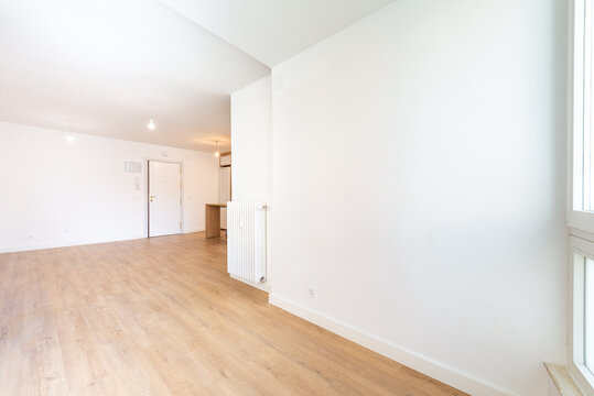 Spacious empty apartment with wood flooring and natural light