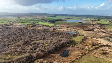 Aerial view of a rural countryside under a bright sky in New Cumnock, Scotland