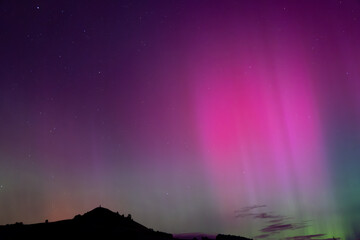 Aurora Australis with pink beams over Puketapu mountain in Palmerston, Otago. Palmerston is located...