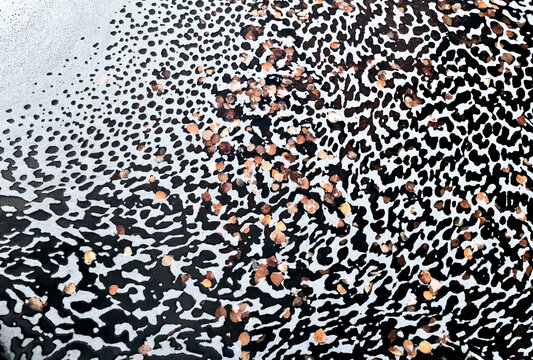 Foam patterns and trapped birch leaves in a pond