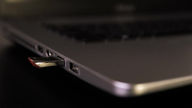 USB flash drive connected to a laptop. Hand disconnecting Usb flash drive cable to computer. Plug / unplug flash drive to netbook. Connecting an external disk. External memory drive. Close-up shot.