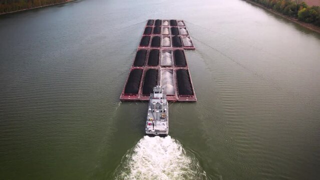 Drone footage of big coal and sand barge travel on Ohio River