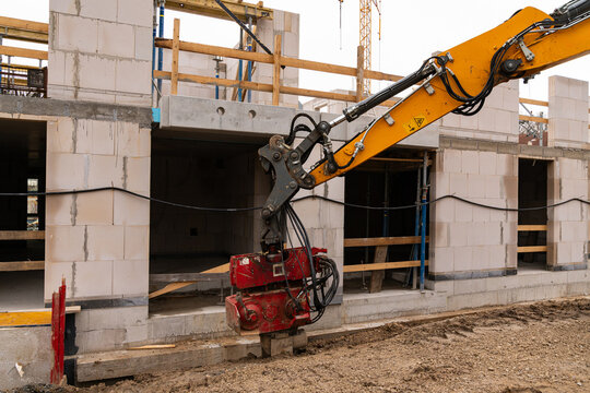 Soil compaction at the foundation of a building under construction using hydraulic technology.