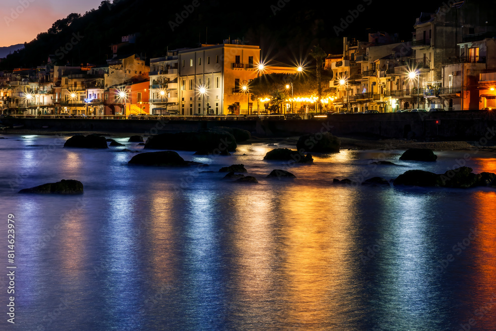 Wall mural evening or night landscape of sea gulf with calm water and beautiful evening town highlighted with with lanterns and flashlights