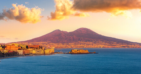 beautiful panorama of volcano Vesuveus from Naples with blue water of sea gulf, majectic mountain and amazing cloudy sunset sky on background © Yaroslav