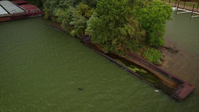 Drone footage of rusty sand carriers on the shoreline of Towhead Island in Ohio River, Kentucky, USA