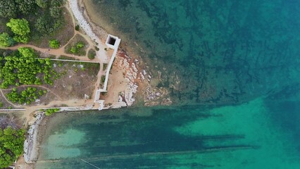 aerial view of the ocean, beach and small lighthouse in its habitat