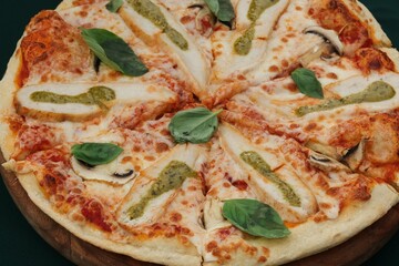 Closeup of a freshly made pizza topped with spinach leaves.