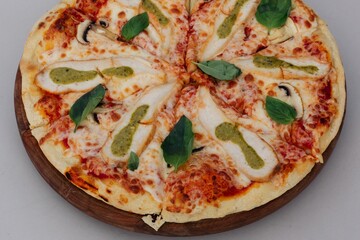 Closeup of a freshly made pizza topped with spinach leaves.