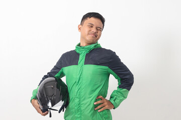 Portrait of tired Asian online taxi driver wearing green jacket holding a helmet on hip and feeling exhausted. Isolated image on white background