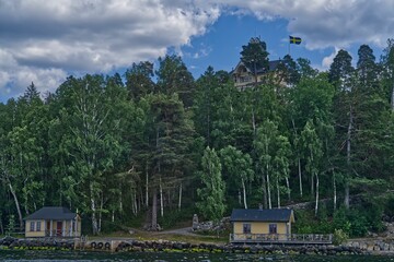 Obraz premium houses on a shore line the water and some trees and grass