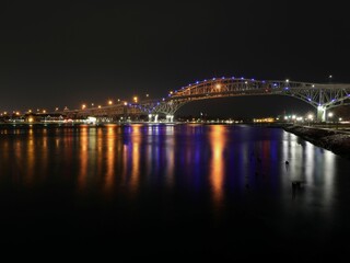 the bridge over the water at night, lit up for night