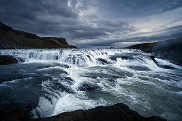 waterfalls are pouring over and into the water in the mountains