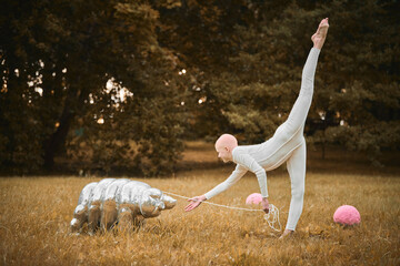 Portrait of young hairless girl ballerina with alopecia in white cloth playing with tardigrade toy...