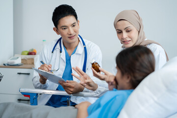 Fototapeta premium medicine, healthcare and people concept - doctor talking to male patient at bed in hospital.