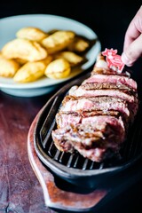 Close-up shot of a man assembling a hearty meal of grilled beef and potatoes