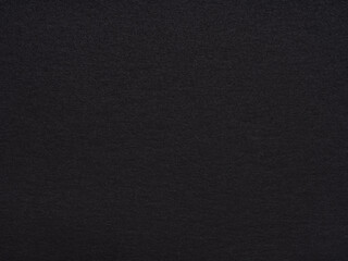 A vast expanse of textured black paper stretches out, evoking depth and a quiet, complex simplicity