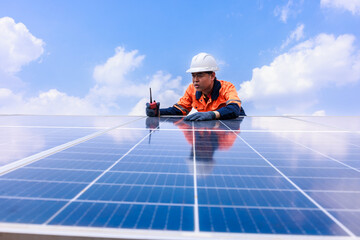 Engineer einspects solar panels, angle view blue sky backgrounds,