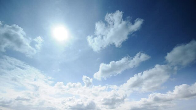 Time lapse low angle footage of the winter clouds movements in the blue sky with bright sun