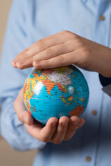 Close-up of man holding a globe in his hands. The concept of the individual's care for the planet's well-being.