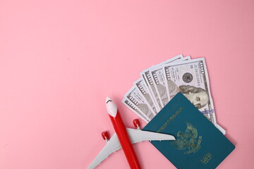 Indonesian Passport And Money With Airplane Over Pink Background With Copy Space. 