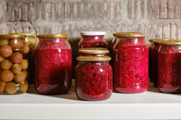 Jars of pickled vegetables. Canned jars of fruit and vegetables in the cellar. Selective focus