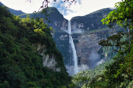 majestic Gocta Falls cascading down from a rocky mountain peak, surrounded by lush greenery