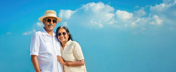 Happy Indian Couple Enjoying a Beautiful Sunny Day Against Blue Sky. Travel Concept.