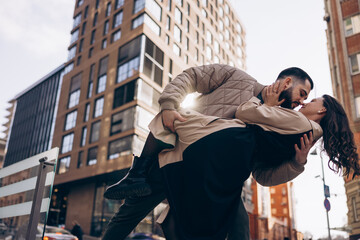 Happy young couple kissing and embracing on city street.